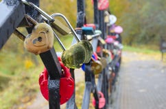 Goldenes Herz-förmiges Vorhängeschloß abgedeckt durch Wassertropfen im regnerischen Herbsttag lizenzfreies stockbild Goldenes Herz-förmiges Vorhängeschloß abgedeckt durch Wassertropfen im regnerischen Herbsttag lizenzfreies stockbild