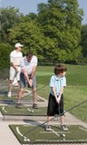 Golf de pratique de famille photographie stock libre de droits Golf de pratique de famille photographie stock libre de droits