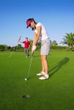 Golf woman player green putting hole golf ball