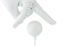 Golfisty use dwa palce trzyma piłkę golfową na trójniku z białym backg zdjęcie royalty free Golfisty use dwa palce trzyma piłkę golfową na trójniku z białym backg zdjęcie royalty free