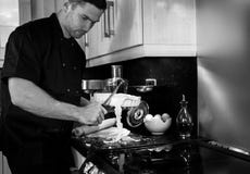 Good looking male chef cutting off excess pastry from dish royalty free stock images Good looking male chef cutting off excess pastry from dish royalty free stock images