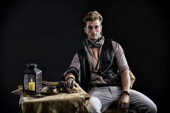 Good Looking Young Man In Pirate Fashion Outfit Sitting Next To Table Royalty Free Stock Photography