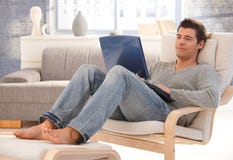 Goodlooking young man relaxing at home with laptop