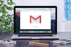 Google Gmail logo on Apple MacBook display in office workplace