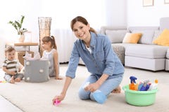 Gospodyni domowej cleaning dywan podczas gdy jej dzieci fotografia royalty free Gospodyni domowej cleaning dywan podczas gdy jej dzieci fotografia royalty free