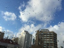 Gotas da chuva no windowpane contra construções Imagens de Stock Royalty Free Gotas da chuva no windowpane contra construções Imagens de Stock Royalty Free