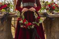 Gothic girl bride wearing a red brocade dress holds a wreath of stock images Gothic girl bride wearing a red brocade dress holds a wreath of stock images