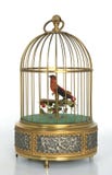 Gouden muzikale vogelkooi met rode vogel royalty-vrije stock afbeeldingen Gouden muzikale vogelkooi met rode vogel royalty-vrije stock afbeeldingen