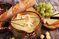 Gourmet- schweizisk fonduematst?lle p? en vinterafton med blandade ostar p? ett br?de tillsammans med en upphettad kruka av ostfo arkivfoto Gourmet- schweizisk fonduematst?lle p? en vinterafton med blandade ostar p? ett br?de tillsammans med en upphettad kruka av ostfo arkivfoto