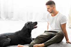Grabb med hans hund som hemma sitter att spela arkivfoto Grabb med hans hund som hemma sitter att spela arkivfoto