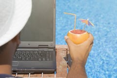 Grabb som arbetar på bärbara datorn och tycker om hans sommarsemester royaltyfria bilder Grabb som arbetar på bärbara datorn och tycker om hans sommarsemester royaltyfria bilder