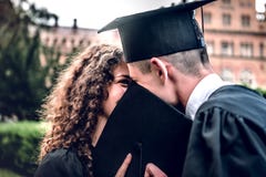 Graduatiedag! Een houdend van paar van gediplomeerden die zich dichtbij universitair bevinden en elkaar glimlachen royalty-vrije stock foto Graduatiedag! Een houdend van paar van gediplomeerden die zich dichtbij universitair bevinden en elkaar glimlachen royalty-vrije stock foto