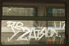 Graffiti scrawled on the glass of an electric train backlit by a backlight against an empty carriage royalty free stock images Graffiti scrawled on the glass of an electric train backlit by a backlight against an empty carriage royalty free stock images