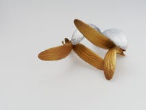 Graine en caoutchouc d'or et d'argent avec deux feuilles sur le fond blanc photos libres de droits Graine en caoutchouc d'or et d'argent avec deux feuilles sur le fond blanc photos libres de droits