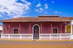 GRANADA, NIKARAGUA, MAJ, 14, 2018: Plenerowy widok fasadowi budynki z menchii ścianą, drewnianym drzwi i dachem w wspaniałym, fotografia royalty free GRANADA, NIKARAGUA, MAJ, 14, 2018: Plenerowy widok fasadowi budynki z menchii ścianą, drewnianym drzwi i dachem w wspaniałym, fotografia royalty free