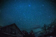Granaio rurale della cabina di ceppo alla notte con le stelle e la Via Lattea fotografia stock libera da diritti Granaio rurale della cabina di ceppo alla notte con le stelle e la Via Lattea fotografia stock libera da diritti