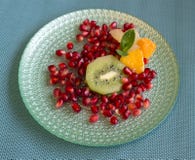 Granatäpple med stycken av kiwin, mandarinen och grapefrukten, med en mintkaramellbladbrytning royaltyfria bilder Granatäpple med stycken av kiwin, mandarinen och grapefrukten, med en mintkaramellbladbrytning royaltyfria bilder