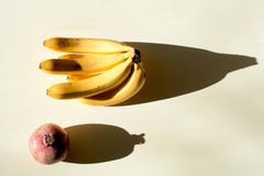 Granatäpple och en grupp av bananer mogen röd saftig granatäpple och en mogen grupp av bananer royaltyfri fotografi Granatäpple och en grupp av bananer mogen röd saftig granatäpple och en mogen grupp av bananer royaltyfri fotografi