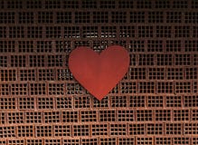 Grand coeur rouge sur les briques empilées d'un mur image stock Grand coeur rouge sur les briques empilées d'un mur image stock