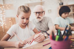 Grand-père, petit-fils et petite-fille à la maison Les enfants dessinent image libre de droits Grand-père, petit-fils et petite-fille à la maison Les enfants dessinent image libre de droits