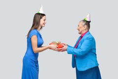 Young woman gives a gift to old funny woman stock photos Young woman gives a gift to old funny woman stock photos