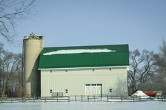 Grande granaio verde bianco del tetto con il silo nella neve di inverno fotografia stock Grande granaio verde bianco del tetto con il silo nella neve di inverno fotografia stock