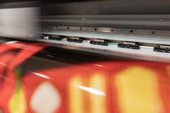 Grande imprimante professionnelle, traitant les petits pains rouges de vinyle massif photo stock Grande imprimante professionnelle, traitant les petits pains rouges de vinyle massif photo stock
