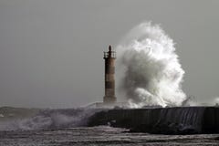 Grande onde contre le phare photographie stock libre de droits Grande onde contre le phare photographie stock libre de droits
