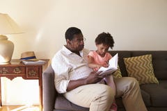 Grandfather And Granddaughter Reading Book At Home Together stock images Grandfather And Granddaughter Reading Book At Home Together stock images