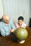 Grandfather and grandson sit on table with globe - stock photos Grandfather and grandson sit on table with globe - stock photos