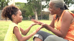 Grandmother And Granddaughter Playing In Park Together