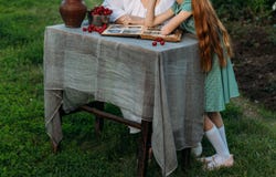 Grandmother sits at the table with her granddaughter, shows her an old album with photos of her youth. on the table is a clay vase royalty free stock photos Grandmother sits at the table with her granddaughter, shows her an old album with photos of her youth. on the table is a clay vase royalty free stock photos