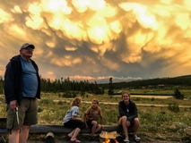 Grandpa with Grandchildren Looking at Stunning Stormy Sunset Clouds