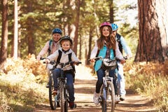 Grandparents and kids cycling on forest trail, California stock photography Grandparents and kids cycling on forest trail, California stock photography