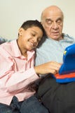 Grandson resting head on grandfather - Vertical stock image Grandson resting head on grandfather - Vertical stock image