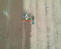 Grano di trasferimento della mietitrebbiatrice al rimorchio del camion, vista aerea del raccolto immagine stock Grano di trasferimento della mietitrebbiatrice al rimorchio del camion, vista aerea del raccolto immagine stock