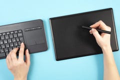 Graphics tablet and keyboard on a blue background. Space for text.Keyboard stock image Graphics tablet and keyboard on a blue background. Space for text.Keyboard stock image