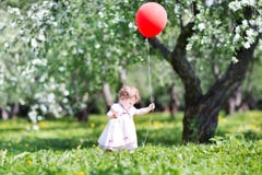 Grappig babymeisje in de tuin van de appelboom met rode impuls royalty-vrije stock foto's Grappig babymeisje in de tuin van de appelboom met rode impuls royalty-vrije stock foto's