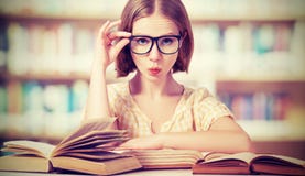 Grappige studente die met glazen boeken lezen stock afbeelding Grappige studente die met glazen boeken lezen stock afbeelding