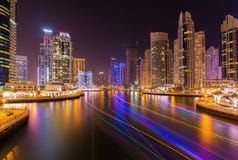 Grattacieli moderni nel porticciolo di lusso del Dubai con passeggiata occupata nella sera, Dubai, Emirati Arabi Uniti immagini stock libere da diritti Grattacieli moderni nel porticciolo di lusso del Dubai con passeggiata occupata nella sera, Dubai, Emirati Arabi Uniti immagini stock libere da diritti