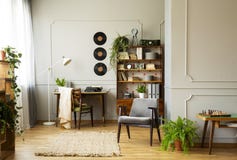 Grauer bequemer Lehnsessel im stilvollen Innenraum der Weinlese mit Anlagen, Buch und Vinylen auf der Wand stockbilder Grauer bequemer Lehnsessel im stilvollen Innenraum der Weinlese mit Anlagen, Buch und Vinylen auf der Wand stockbilder