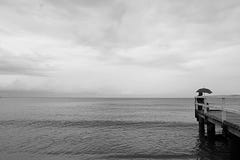 Grauer Tag auf dem Strand von Sopot Polen und ein Mann unter einem Regenschirm auf dem Pier stockbilder Grauer Tag auf dem Strand von Sopot Polen und ein Mann unter einem Regenschirm auf dem Pier stockbilder
