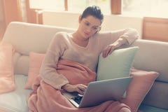 Gravid kvinna som arbetar på en soffa arkivbild Gravid kvinna som arbetar på en soffa arkivbild