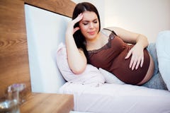 Gravid kvinna som har en dålig huvudvärk arkivfoto Gravid kvinna som har en dålig huvudvärk arkivfoto