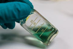 Green chemical transparent liquid in clear bottle holding by che royalty free stock photo Green chemical transparent liquid in clear bottle holding by che royalty free stock photo