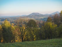 Green meadow with autumn colorful forest and trees and hills bef Stock Photos Green meadow with autumn colorful forest and trees and hills bef Stock Photos