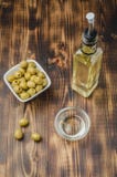 Green Olives In A White Ceramic Bowl And Glass Bottle Of Olive Oil On A Wooden Background. Top View Royalty Free Stock Image