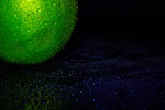Green ripe apple with water droplets on a dark background, closeup royalty free stock photos Green ripe apple with water droplets on a dark background, closeup royalty free stock photos