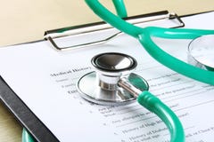Green stethoscope lying on a medical record