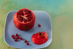 Grenade et graines rouges de fruit d'un plat bleu Beau fruit tropical lumineux image libre de droits Grenade et graines rouges de fruit d'un plat bleu Beau fruit tropical lumineux image libre de droits
